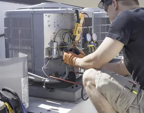 A professional HVAC repair technician from Perfect Temp using specialized tools to diagnose a furnace issue and restore home heating.