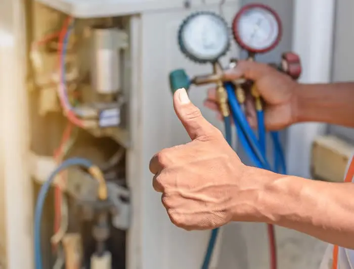 Reliable HVAC repair services in the South Sound; a technician confirms a successful system tune-up with a thumbs up for a local homeowner.