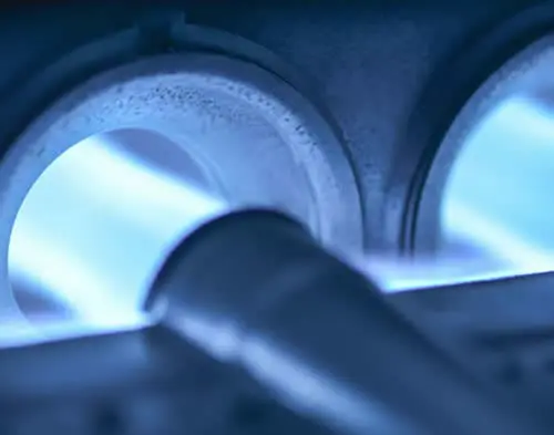 Detailed view of furnace gas burners during a combustion analysis to ensure proper fuel-to-air ratio and safe operation