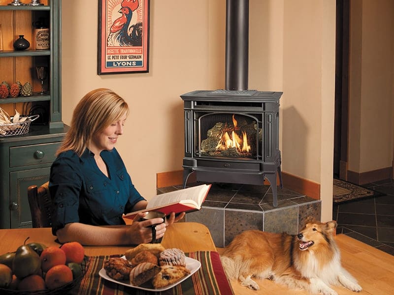 Gas-Fireplace-With-Woman Residential gas fireplace installation providing supplemental heat and a beautiful focal point for a cozy living room.
